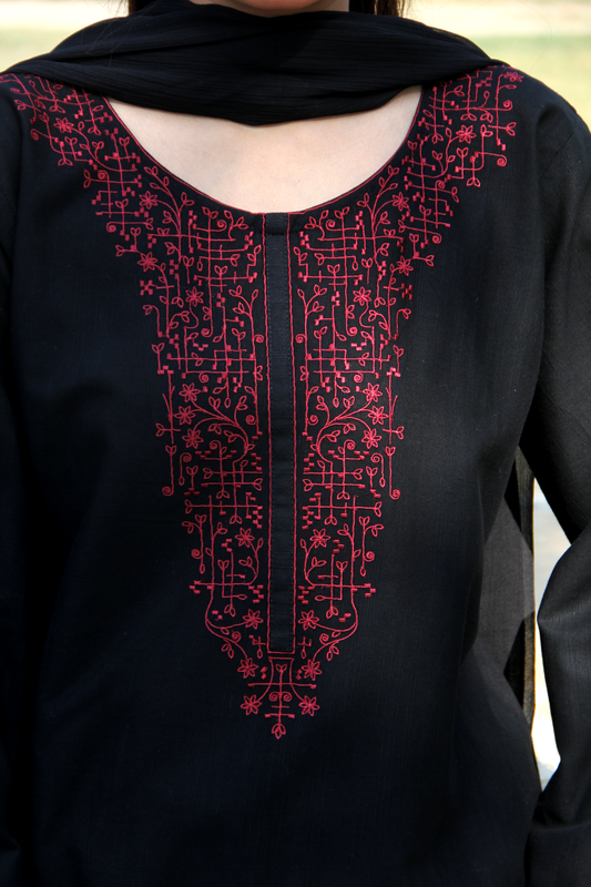 Black garment with red embroidery on a blurred background